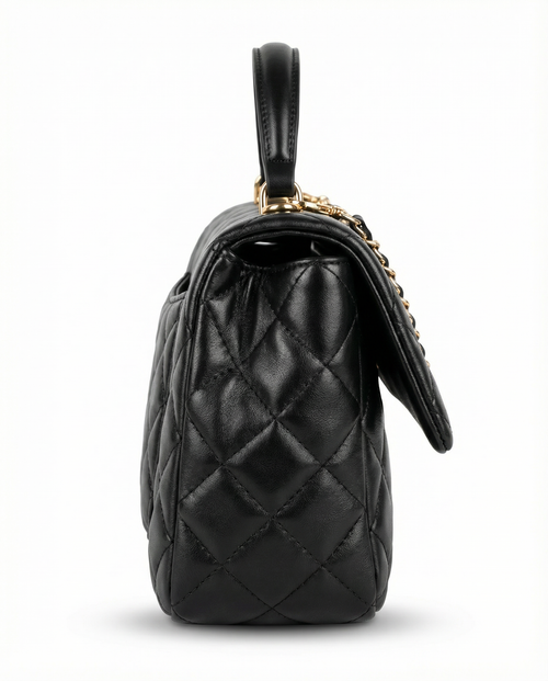 Side profile of black quilted ChristAdorn handbag with structured silhouette and gold hardware.