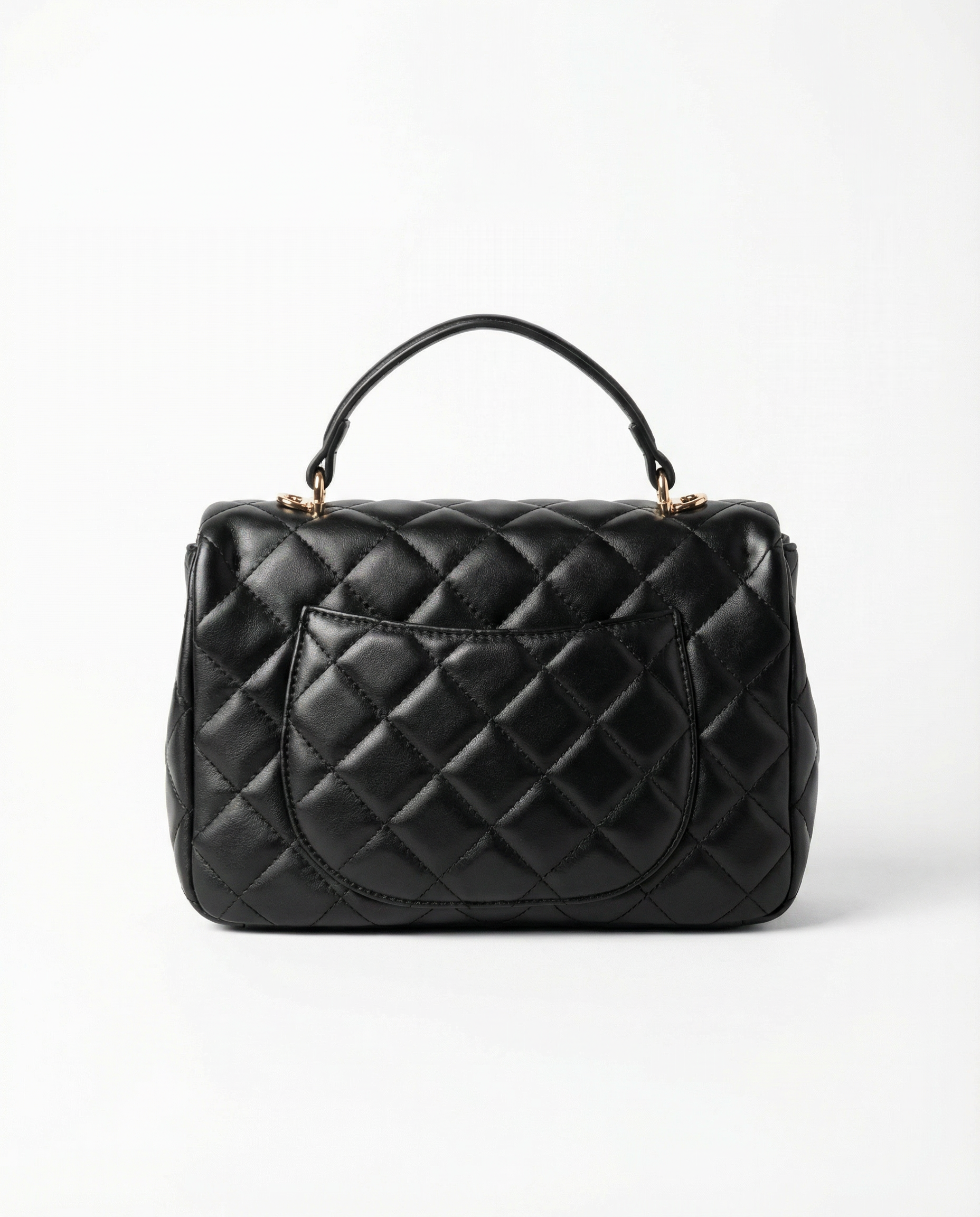 Back view of black quilted ChristAdorn handbag with rear slip pocket and top handle.